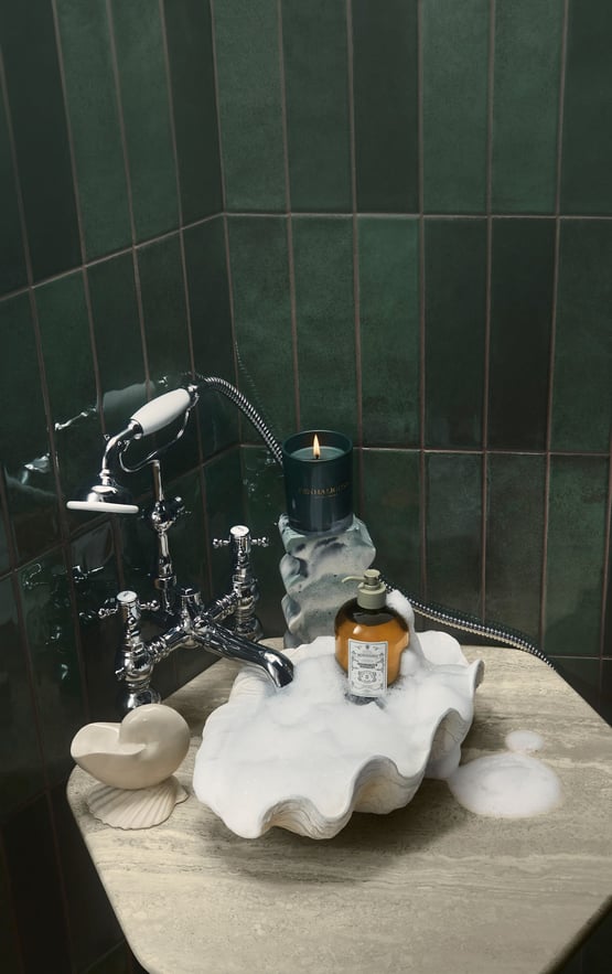 Highgrove Bouquet body wash and candle in marble shell-shaped sink and pine green bathroom tiles
